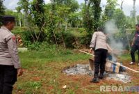 Caption: anggota Polsek Sokobanah tampak membakar alat yang digunakan sebagai arena judi sabung ayam, (dok. Humas Polres Sampang). 