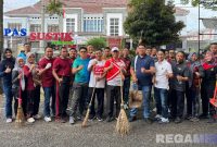 Caption: Kepala dan pegawai Lapas Narkotika Pamekasan pose bersama membawa peralatan bersih-bersih lingkungan. 