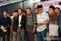 Caption: Jakfar Sodiq  (jas hitam) bersama tokoh dan pemuda Sampang memberikan keterangan kepada awak media usai melaporkan akun Tiktok @faktapolitiktok.