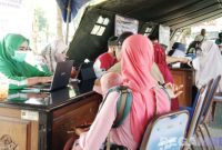 Caption: tampak petugas Puskemas Kamoning saat mendata dan memberikan layanan cek kesehatan gratis kepada masyarakat, (dok. regamedianews). 