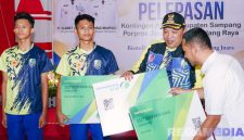 Caption: Bupati Sampang (H.Slamet Junaidi) secara simbolis menyerahkan kartu peserta BPJS Ketanagakerjaan kepada atlet KONI Sampang. 