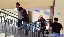Caption: Kasat Reskrim Polres Sampang dan anggotanya, saat menggiring satu pelaku pembacokan (peci hitam) ke ruangan penyidik. 