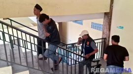Caption: Kasat Reskrim Polres Sampang dan anggotanya, saat menggiring satu pelaku pembacokan (peci hitam) ke ruangan penyidik. 
