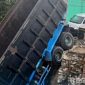 Caption: akibat kecelakaan, tampak truk fuso nyungsep di bekas galian proyek revitalisasi jembatan di jalur jalan raya Tanah Merah Bangkalan. 