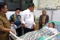 Caption: didampingi Kades Blu'uran dan Plt Dirut RSMZ, Bupati Sampang H.Slamet Junaidi saat menjenguk Ketua PABPDSI Sampang yang terbaring sakit. 