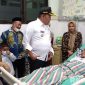 Caption: didampingi Kades Blu'uran dan Plt Dirut RSMZ, Bupati Sampang H.Slamet Junaidi saat menjenguk Ketua PABPDSI Sampang yang terbaring sakit. 