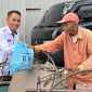 Caption: salah satu pejabat struktural Lapas Narkotika Pamekasan saat memberikan bantuan paket sembako kepada tukang becak. 