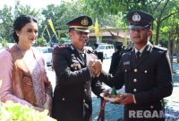 Caption: didampingi istri, Kapolres Bangkalan AKBP Hendro Sukmono berikan potongan tumpeng kepada anggotanya saat momen Hari Bhayangkara ke-79. 