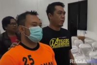 Caption: inisial ZA, tersangka penganiayaan kurir ekspedisi tampak memakai baju tahanan dan dikawal anggota Satreskrim Polres Pamekasan, (dok. regamedianews). 