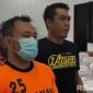 Caption: inisial ZA, tersangka penganiayaan kurir ekspedisi tampak memakai baju tahanan dan dikawal anggota Satreskrim Polres Pamekasan, (dok. regamedianews). 