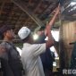 Caption: pihak keluarga menunjukkan lokasi ditemukannya korban dalam kondisi gantung diri didalam kandang sapi, (sumber foto: Polsek Palengaan). 