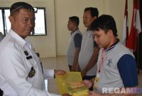 Caption: Kalapas Narkotika Pamekasan (Kusnan) memberikan buku panduan program kemandirian berupa pelatihan pengelasan kepada warga binaan. 