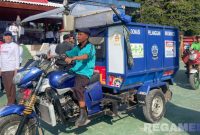 Caption: petugas kebersihan tampak mengendarai kendaraan pengangkut sampah usai peluncuran program 'Bangkalan Bherse Ongghu',  (dok. regamedianews). 