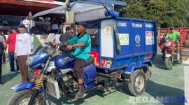 Caption: petugas kebersihan tampak mengendarai kendaraan pengangkut sampah usai peluncuran program 'Bangkalan Bherse Ongghu',  (dok. regamedianews). 
