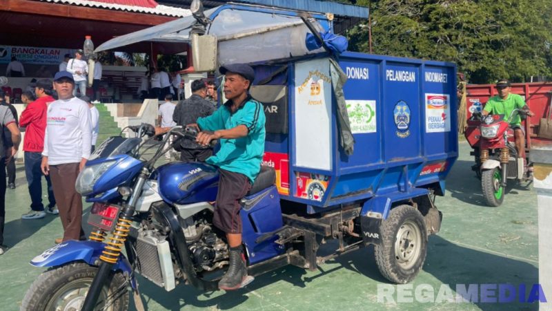 Caption: petugas kebersihan tampak mengendarai kendaraan pengangkut sampah usai peluncuran program 'Bangkalan Bherse Ongghu',  (dok. regamedianews). 