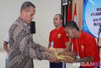 Caption: Kakanwil Ditjenpas Jatim (Kadiyono) menyerahkan buku panduan program rehabilitasi kepada warga binaan Lapas Narkotika Pamekasan. 