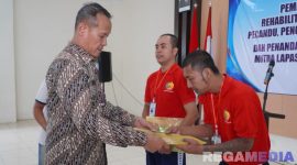 Caption: Kakanwil Ditjenpas Jatim (Kadiyono) menyerahkan buku panduan program rehabilitasi kepada warga binaan Lapas Narkotika Pamekasan. 