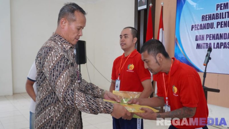 Caption: Kakanwil Ditjenpas Jatim (Kadiyono) menyerahkan buku panduan program rehabilitasi kepada warga binaan Lapas Narkotika Pamekasan. 
