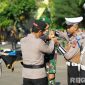 Caption: Kapolres Sampang AKBP Hartono pasang pita kepada personel TNI, saat apel Operasi Patuh Semeru 2025, (sumber foto: Humas Polres Sampang). 