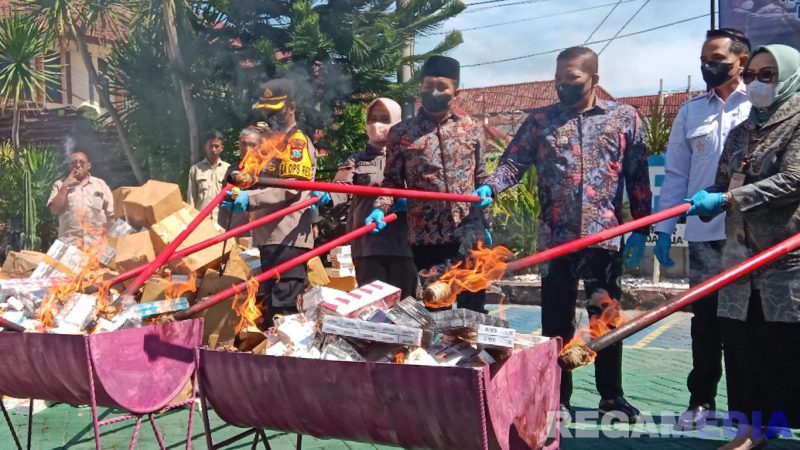 Caption: terlihat, Kajari bersama Dandim, Kapolres, Bupati, Ketua DPRD, Karutan dan Ketua Pangadilan membakar BB rokok ilegal, (dok. regamedianews). 