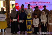 Caption: ahli waris dari tukang becak menerima santunan JKM dari BPJS Ketenagakerjaan dan pose bersama Bupati Sumenep, (dok. BPJS Ketenagakerjaan Sumenep). 
