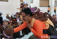 Caption: Fasilitator SPAB FRPB saat mengajarkan siswa TK tindakan penyelamatan saat terjadi bencana, (dok. regamedianews). 