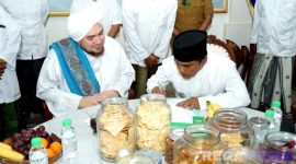 Caption: Bupati Bangkalan Lukman Hakim tanda tangani Surat Edaran 'Berdoa', didepan habaib dan ulama', (dok. Prokopim Pemkab Bangkalan). 