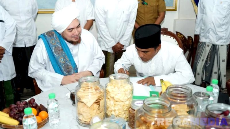 Caption: Bupati Bangkalan Lukman Hakim tanda tangani Surat Edaran 'Berdoa', didepan habaib dan ulama', (dok. Prokopim Pemkab Bangkalan). 