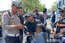 Caption: Kasat Lantas Polres Sampang, AKP Sigit Ekan Sahudi, cek surat kendaraan pengendara motor saat gelar Operasi Patuh Semeru 2025 di wilayah Kecamatan Ketapang, (dok. Polantas Sampang). 
