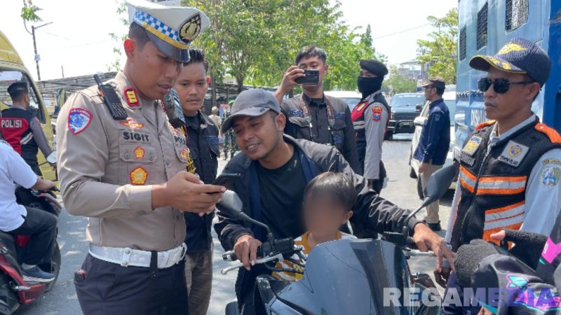 Caption: Kasat Lantas Polres Sampang, AKP Sigit Ekan Sahudi, cek surat kendaraan pengendara motor saat gelar Operasi Patuh Semeru 2025 di wilayah Kecamatan Ketapang, (dok. Polantas Sampang). 