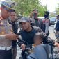 Caption: Kasat Lantas Polres Sampang, AKP Sigit Ekan Sahudi, cek surat kendaraan pengendara motor saat gelar Operasi Patuh Semeru 2025 di wilayah Kecamatan Ketapang, (dok. Polantas Sampang). 
