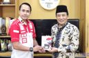 Caption: Kepala Rutan Sampang Kamesworo, memberikan buku karya warga binaan kepada Sekdakab Sampang, Yuliadi Setiyawan, (dok. regamedianews). 
