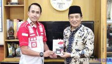 Caption: Kepala Rutan Sampang Kamesworo, memberikan buku karya warga binaan kepada Sekdakab Sampang, Yuliadi Setiyawan, (dok. regamedianews). 