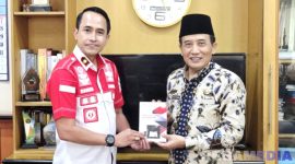 Caption: Kepala Rutan Sampang Kamesworo, memberikan buku karya warga binaan kepada Sekdakab Sampang, Yuliadi Setiyawan, (dok. regamedianews). 