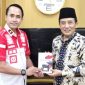Caption: Kepala Rutan Sampang Kamesworo, memberikan buku karya warga binaan kepada Sekdakab Sampang, Yuliadi Setiyawan, (dok. regamedianews). 