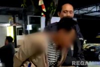 Caption: inisial MA, pelaku pencurian kotak amal masjid, saat digelandang polisi ke Mako Polsek Sokobanah, (dok. regamedianews). 