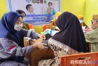 Caption: masyarakat tengah mendapat pelayanan pemeriksaan kesehatan gratis yang digelar HTI Group, (dok. regamedianews). 