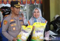 Caption: Kapolres Sampang AKBP Hartono saat melayani langsung masyarakat yang membeli beras murah, (sumber foto: Humas Polres Sampang). 
