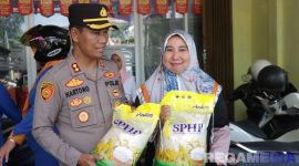 Caption: Kapolres Sampang AKBP Hartono saat melayani langsung masyarakat yang membeli beras murah, (sumber foto: Humas Polres Sampang). 