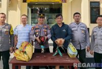 Caption: Kapolsek Sokobanah Iptu Sujiyono bersama anggotanya, menunjukkan dua ekor ayam hasil gerebek lokasi perjudian sabung ayam, (sumber foto: Humas Polres Sampang). 