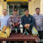 Caption: Kapolsek Sokobanah Iptu Sujiyono bersama anggotanya, menunjukkan dua ekor ayam hasil gerebek lokasi perjudian sabung ayam, (sumber foto: Humas Polres Sampang). 