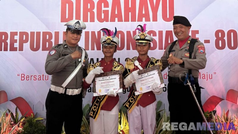 Caption: polisi cilik Raden Nurul Anwar (kanan), menerima reward dan pose bersama dua anggota Polres Sampang, di Pendopo Trunojoyo, (dok. regamedianews). 
