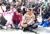 Caption: Kapolres Pohuwato AKBP Bussroni, saat duduk ditengah massa aksi demonstran di Pohuwato, (dok. regamedianews). 