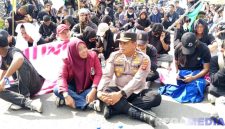 Caption: Kapolres Pohuwato AKBP Bussroni, saat duduk ditengah massa aksi demonstran di Pohuwato, (dok. regamedianews). 