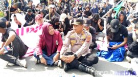Caption: Kapolres Pohuwato AKBP Bussroni, saat duduk ditengah massa aksi demonstran di Pohuwato, (dok. regamedianews). 