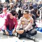 Caption: Kapolres Pohuwato AKBP Bussroni, saat duduk ditengah massa aksi demonstran di Pohuwato, (dok. regamedianews). 