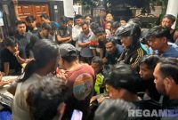Caption: kedua pelaku pencurian burung tengah diinterogasi petugas dan dikerumuni warga, (sumber foto: Humas Polres Sampang). 