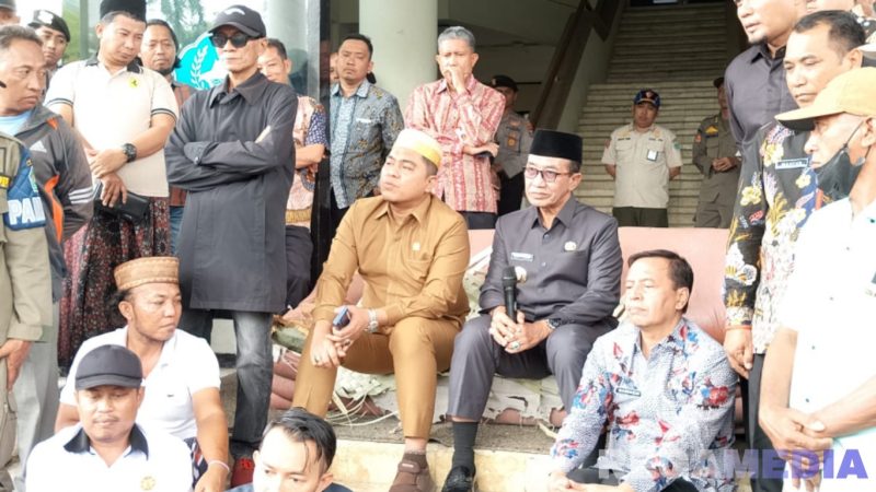 Caption: Bupati Pamekasan Kholilurrahman, menduduki sofa tua yang disuguhkan oleh massa aksi demo, (dok. regamedianews). 
