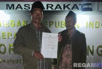 Caption: korban pencurian uang dalam jok motor, tunjukkan surat tanda terima laporan polisi didepan Mako Polres Sampang, (dok. regamedianews). 