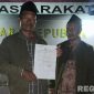 Caption: korban pencurian uang dalam jok motor, tunjukkan surat tanda terima laporan polisi didepan Mako Polres Sampang, (dok. regamedianews). 